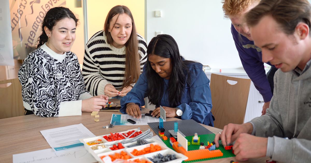 Kinderen werken samen aan een LEGO bouwproject.